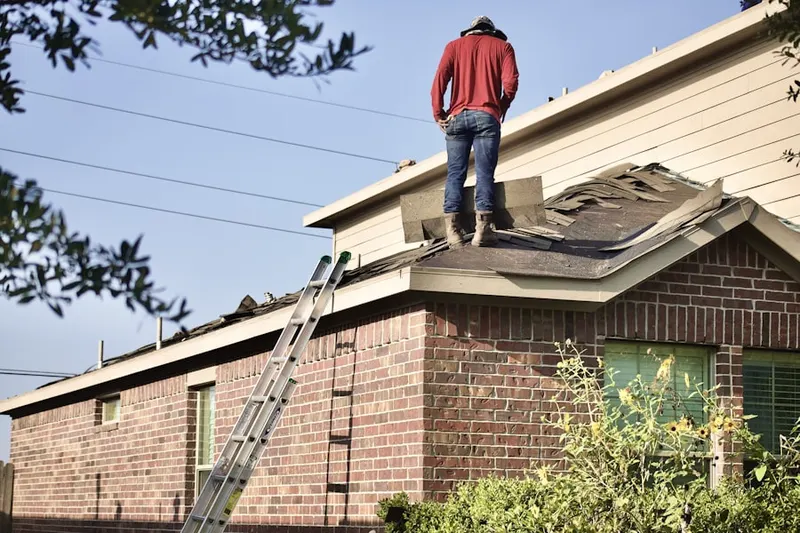 Professional roofer working on a residential roof in Saint Benedict